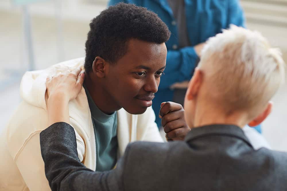 Young man receiving support in a group setting